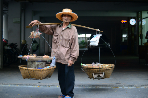 Man With Two Baskets Slung over Wooden Pole